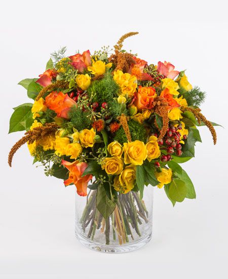 Bouquet dai toni caldi con rose arancio, rose a grappolo, garofani verdi e fiorellini di stagione