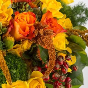Bouquet dai toni caldi con rose arancio, rose a grappolo, garofani verdi e fiorellini di stagione